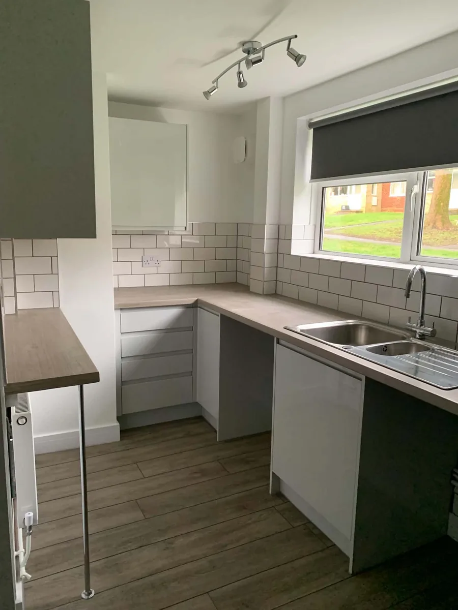 Kitchen sink area with fitted cabinets and worktops in MOD housing.